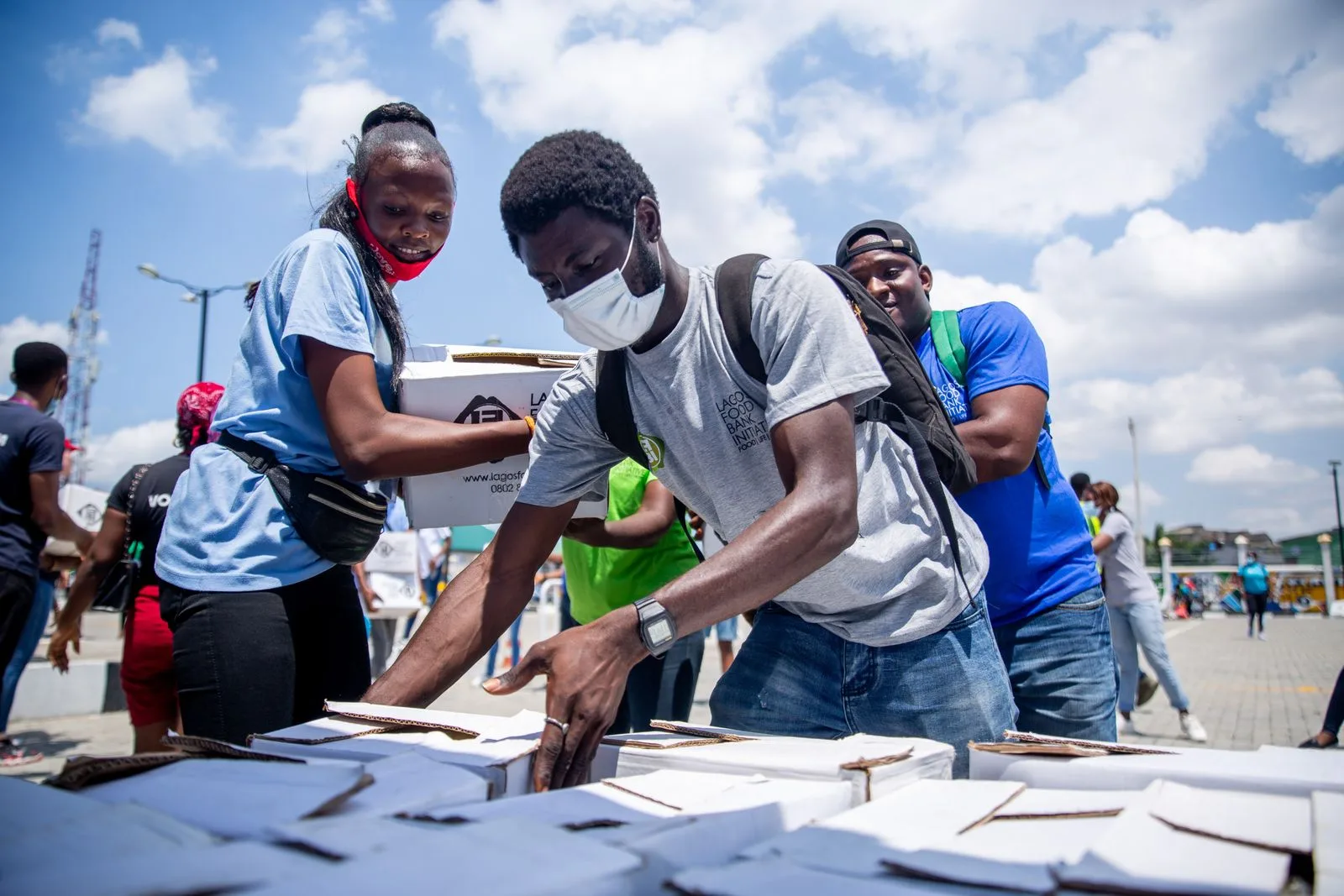 Community volunteers organising supplies together at an outdoor donation distribution event.