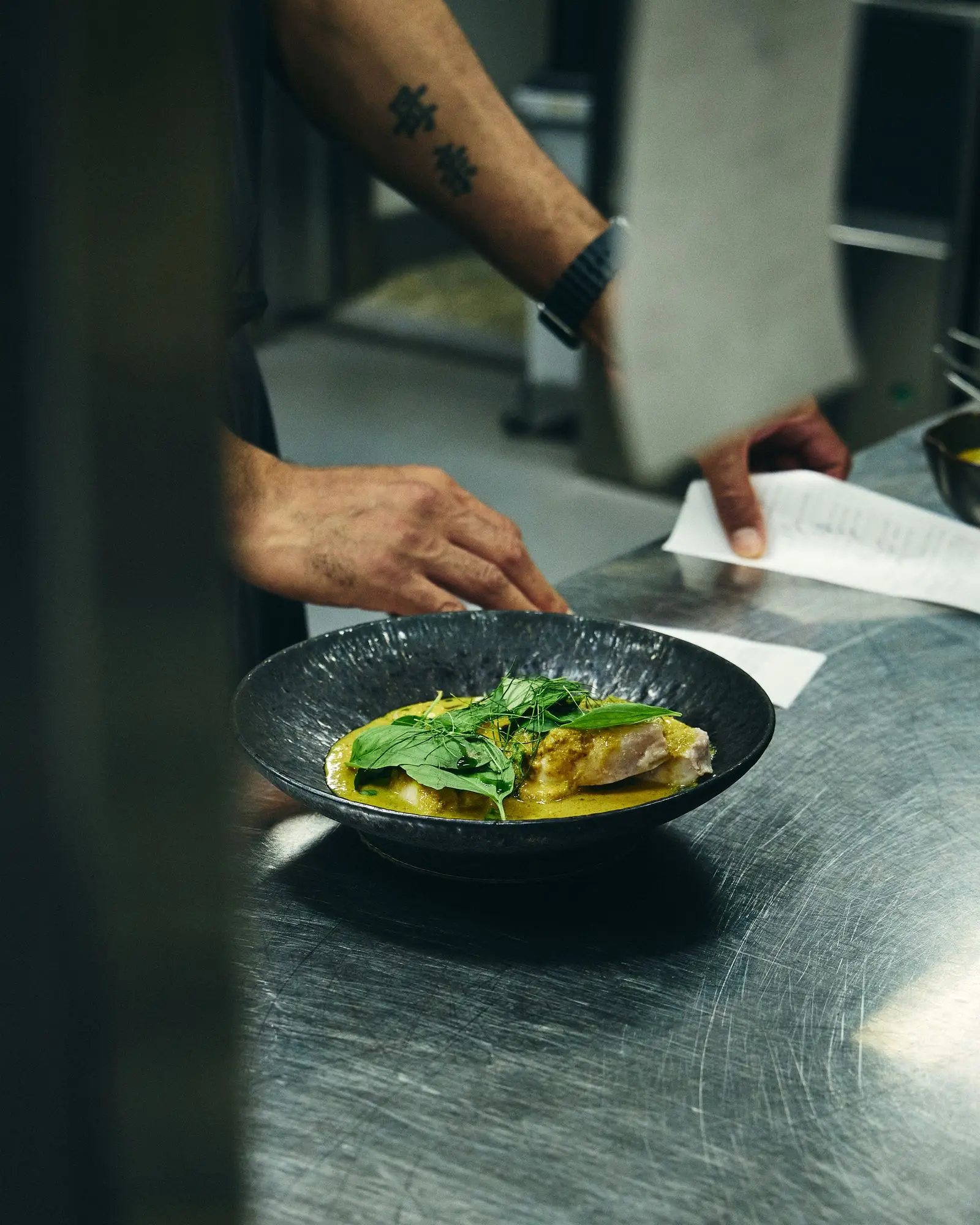 Chef plating a dish during a busy service
