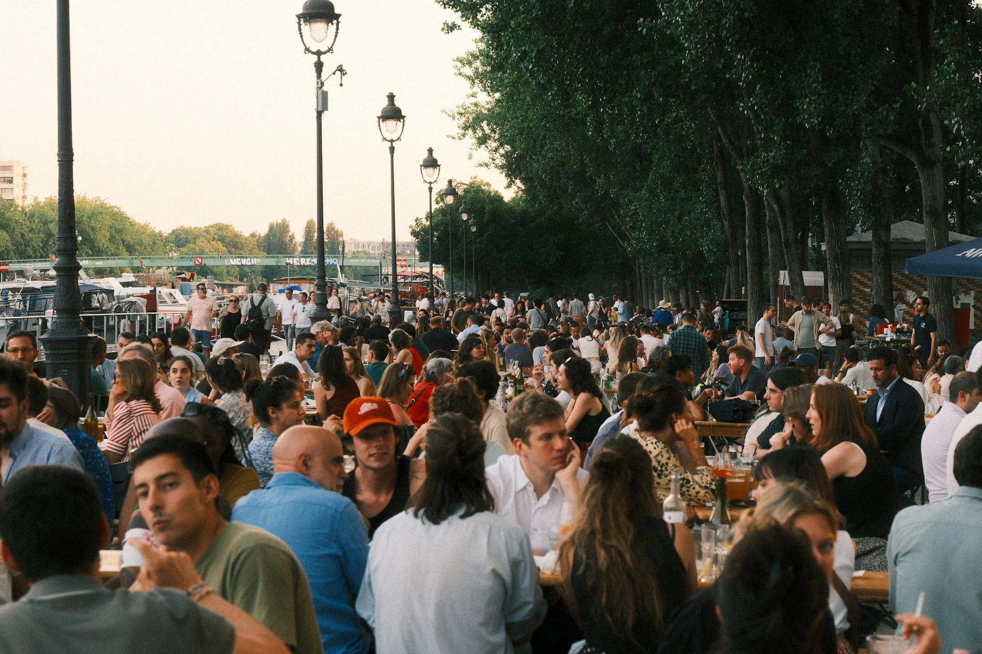 A lively restaurant terrace filled with diners sharing food and conversation.
